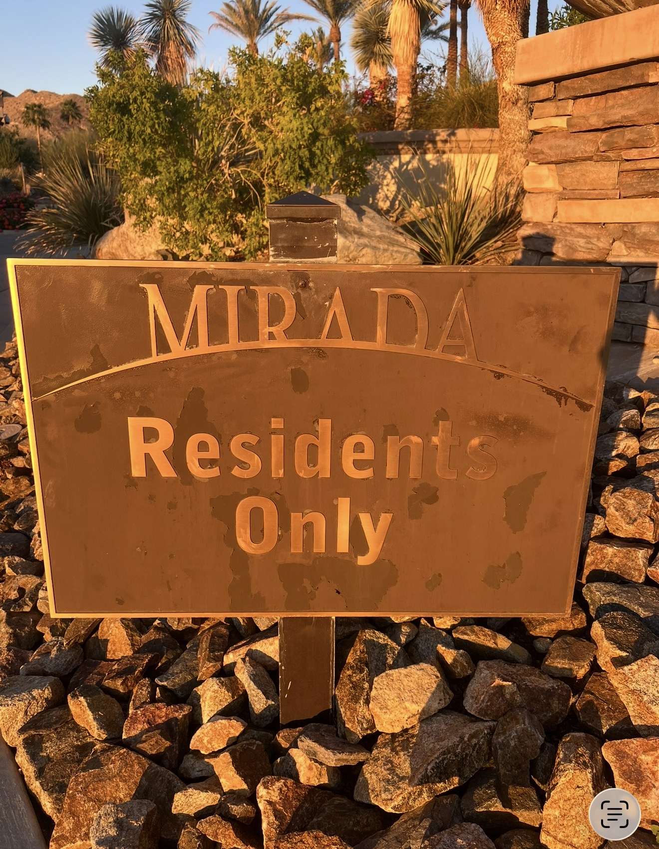 Bronze HOA entry plaque with oxidation and peeling coating before restoration in Palm Springs
